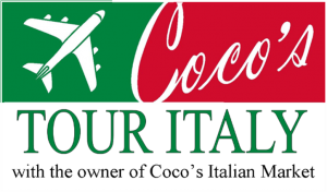 Owner of Coco's Italian Market leading a guided tour through Italy with travelers enjoying authentic cuisine and historic sites.